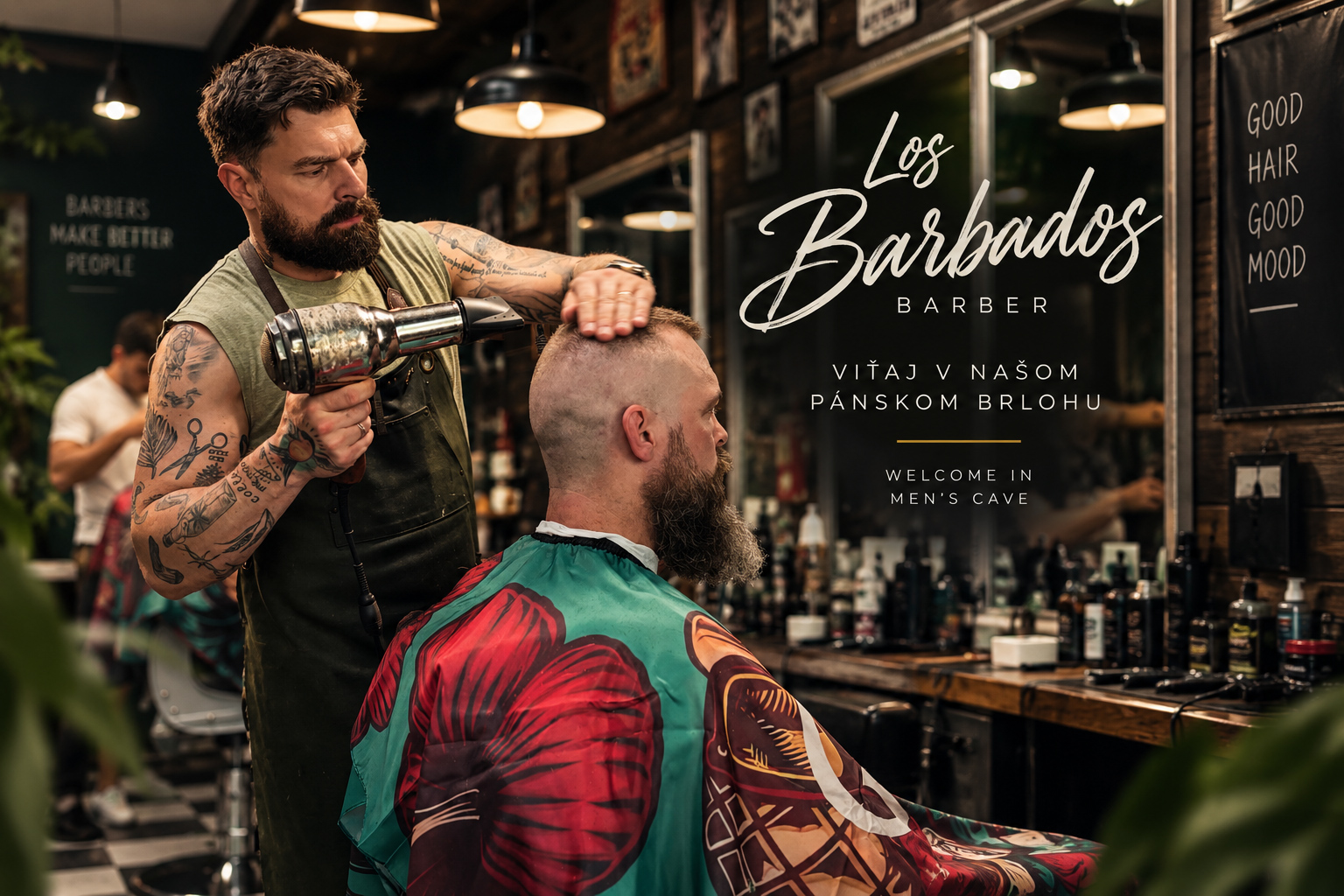 Holíč v barbershope fúka klientovi vlasy fénom, na pozadí nápis Los BarbaDos. Barber pri práci